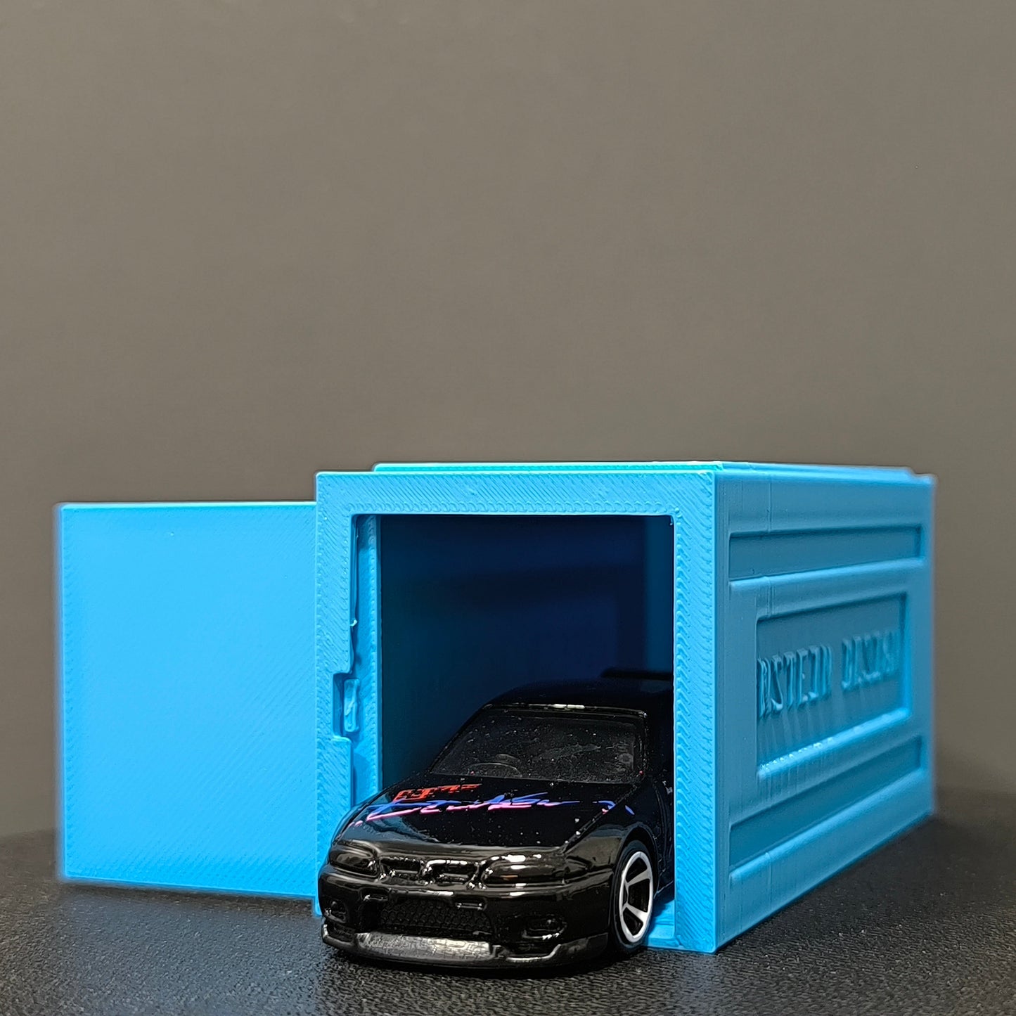 babakék színű hot wheels kisautó garázs